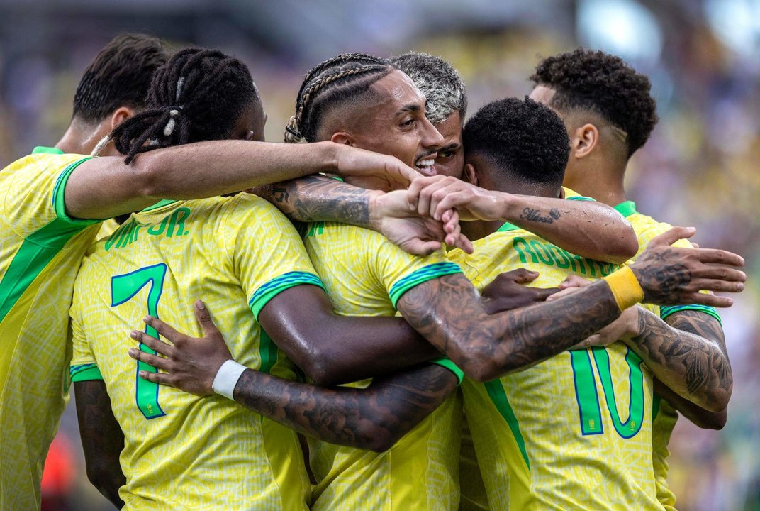 Fotografía de este 13 de junio del jugador brasileño Marquinhos (c) en un abrazo con sus compañeros luego de un gol en un partido amistoso en Orlando, EE.UU. EFE/CRISTOBAL HERRERA