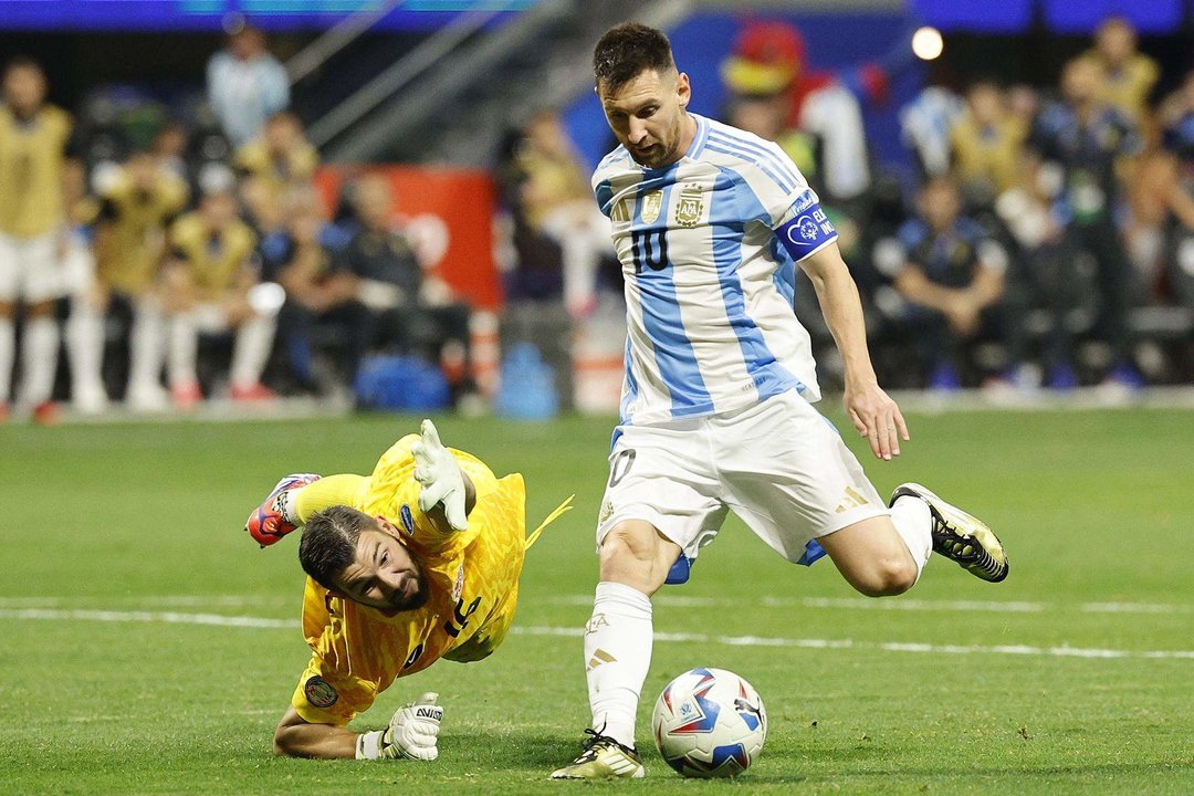 El capitán de la selección de fútbol de Argentina, Lionel Messi (d), fue registrado este jueves, 20 de junio, al intentar superar el bloqueo del guardameta de Canadá, Maxime Crepeau (d), durante el primer partido de la Copa América 2024, en el estadio Mercedes Benz de Atlanta (Georgia, EE.UU.). EFE/Erik S. Lesser