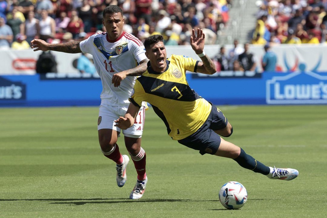 El defensa ecuatoriano Piero Hincapié (d) fue registrado este sábado, 22 de junio, al disputar un balón con el atacante venezolano Darwin Machis (i), durante el primer partido del grupo B de la Copa América, en el Levi´s Stadium de Santa Clara (California, EE.UU.). EFE/John G. Mabanglo