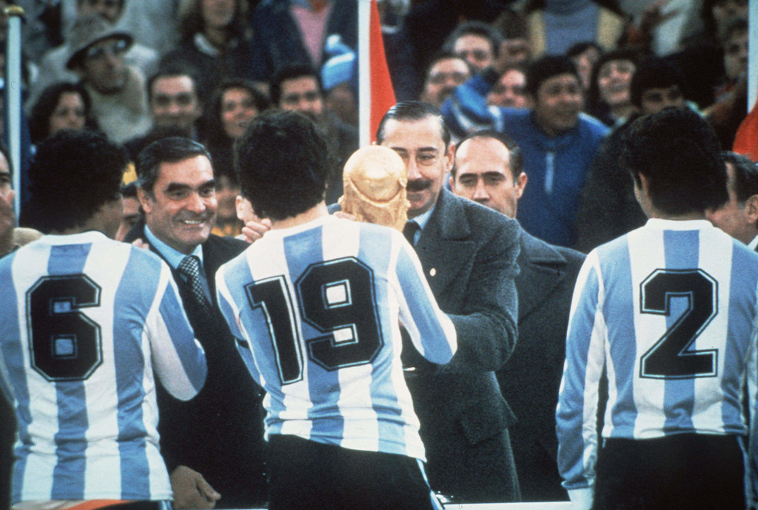 Fotografía de archivo, tomada el 25 de junio de 1978, en la que se registró al entonces presidente de facto de Argentina, Jorge Rafael Videla (c-d), al entregarle a jugadores de la selección argentina de fútbol la copa de campeones del Mundial FIFA, en el estadio Monumental de Buenos Aires (Argentina). EFE